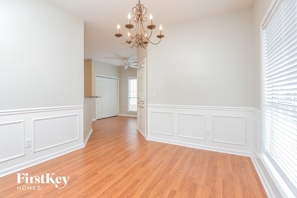 A well-lit room with wooden floors and a chandelier.