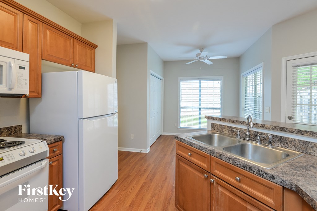A kitchen with wooden cabinets and a white refrigerator.