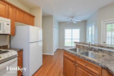 A kitchen with wooden cabinets and a white refrigerator.