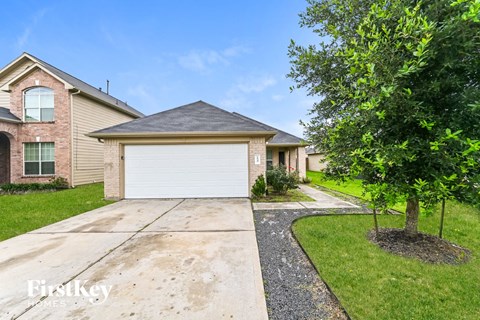 a home with a white garage door and a tree