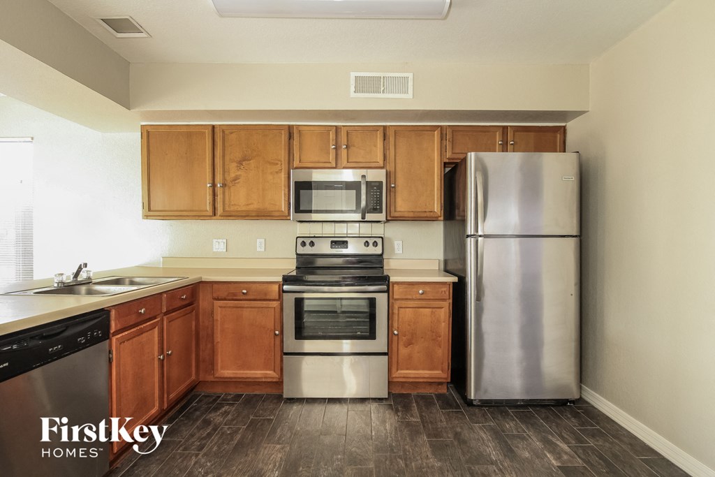 a kitchen with wooden cabinets and stainless steel appliances