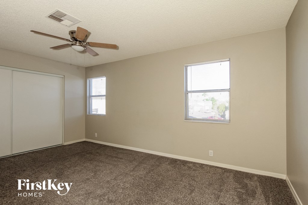 a bedroom with carpet and a ceiling fan