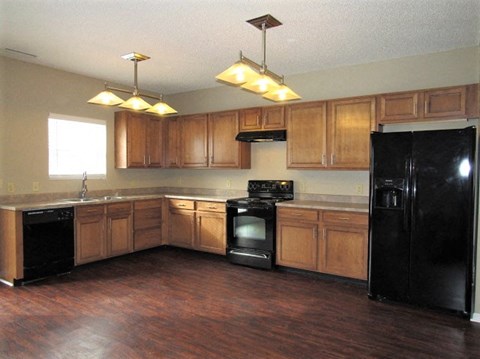 A kitchen with wooden cabinets and black appliances.