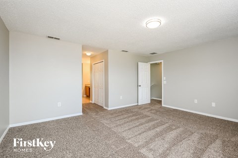 a spacious living room with carpeting and white walls