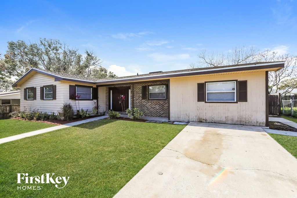 A house with a well-maintained lawn and a clear sky.