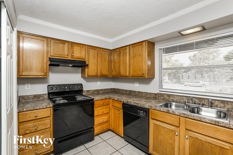 A kitchen with wooden cabinets and black appliances.