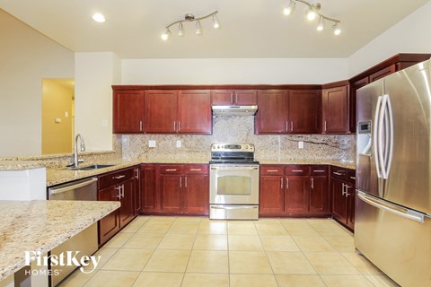 A kitchen with brown cabinets and a stainless steel refrigerator.