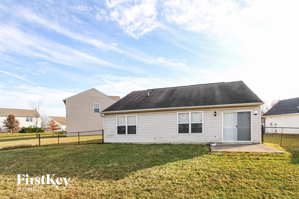 A house with a fence and a grassy yard is for sale.