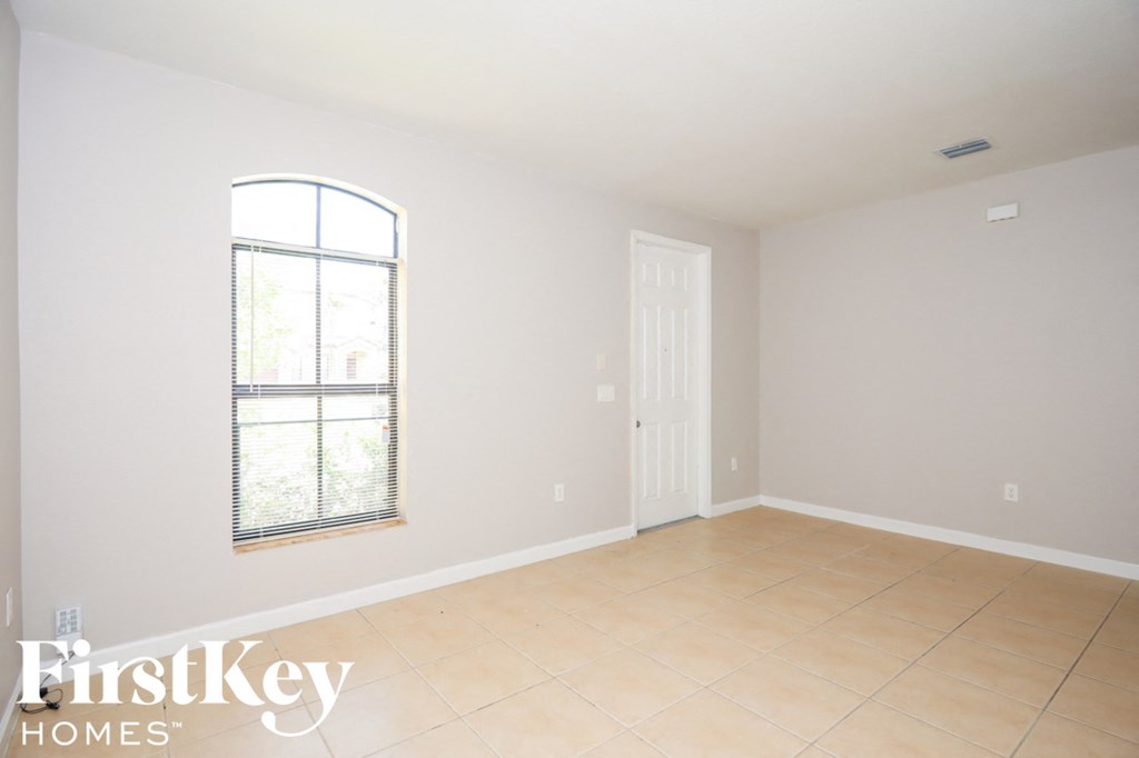 a empty living room with white walls and a window