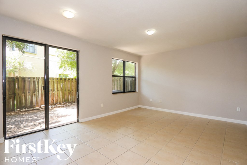 an empty living room with sliding glass doors to the backyard