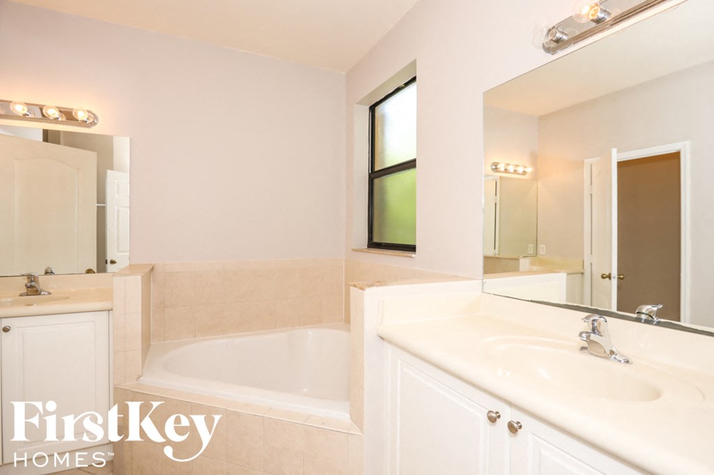 a bathroom with a tub and a sink and a mirror