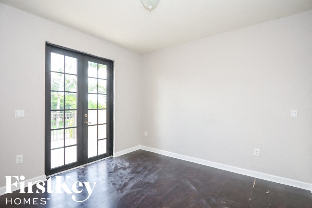 an empty room with white walls and a sliding glass door