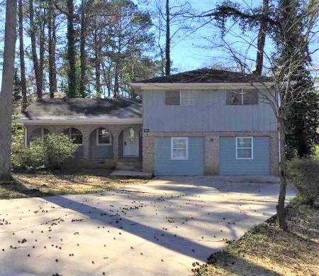 a white house in the middle of the woods