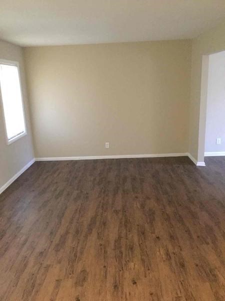 an empty living room with a wooden floor