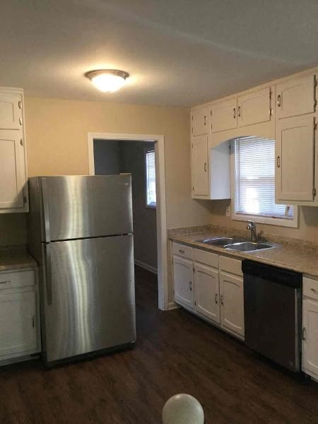 a kitchen with white cabinets and a stainless steel refrigerator