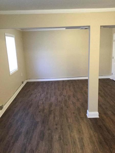 an empty living room with a wooden floor