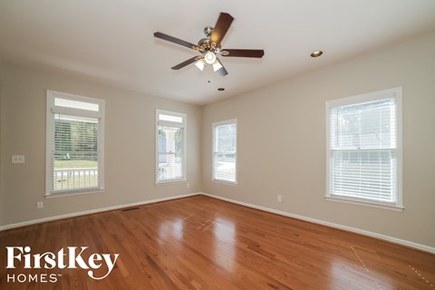 a living room with wood floors and a ceiling fan