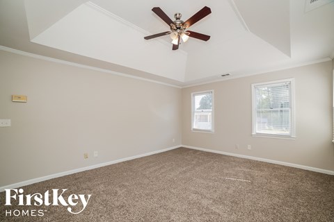 a bedroom with a ceiling fan and a carpeted floor
