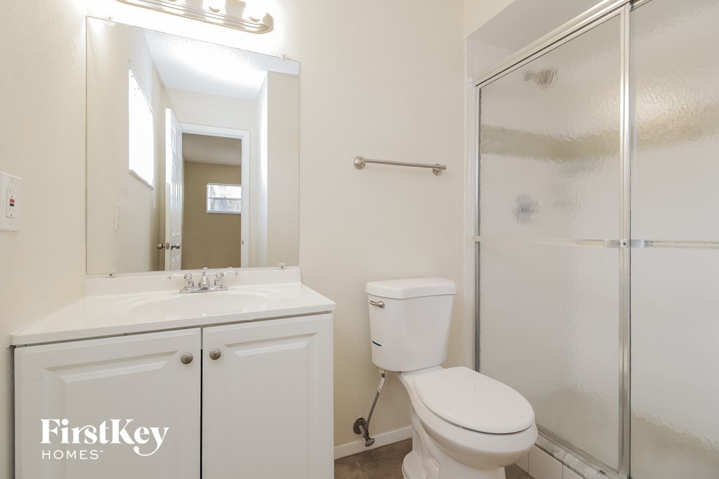 a white bathroom with a shower toilet and sink