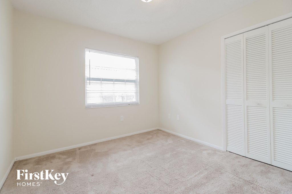 a bedroom with two closets and a window