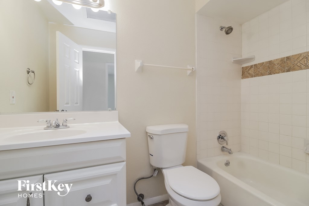 a white bathroom with a white toilet and a tub and a sink
