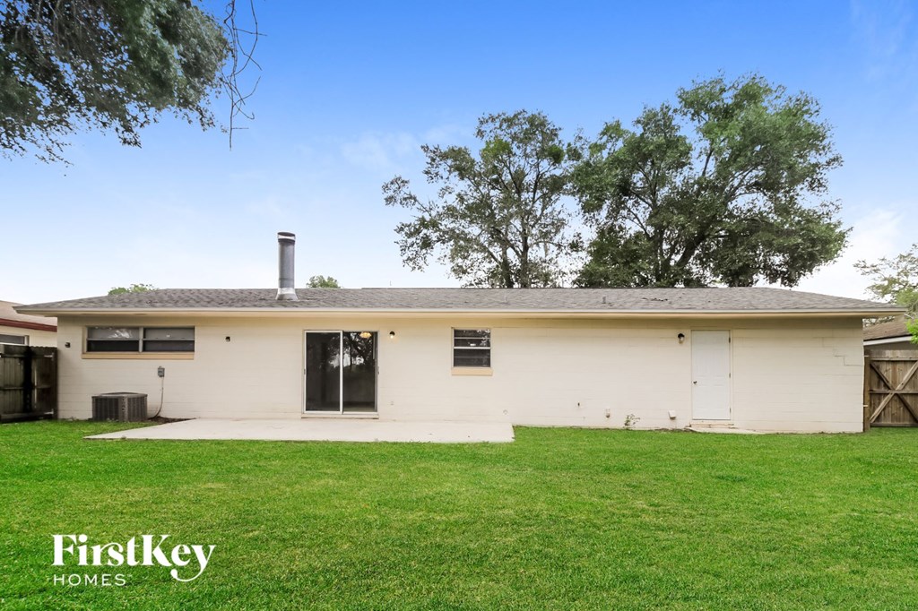 a white house with a green lawn and trees