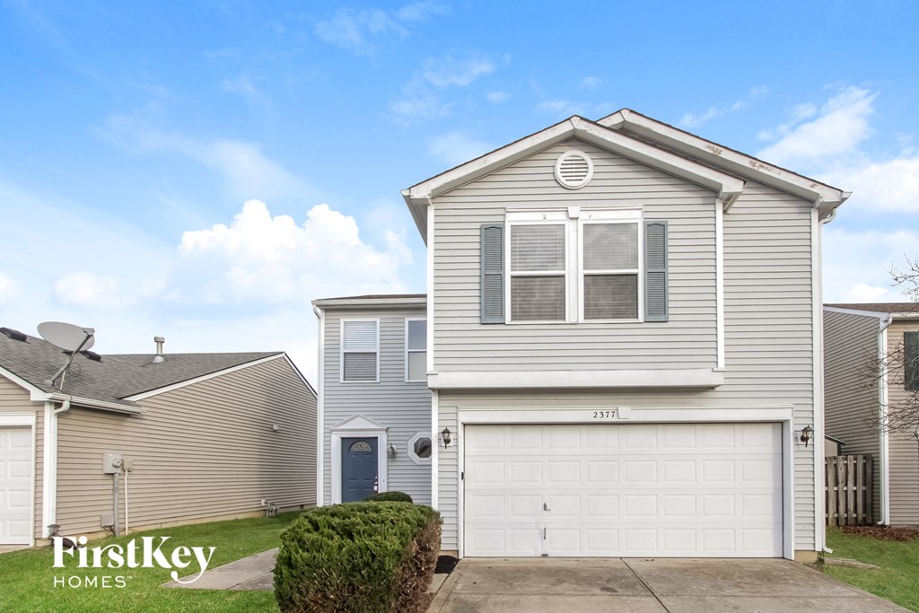 A two-story house with a garage is for sale.