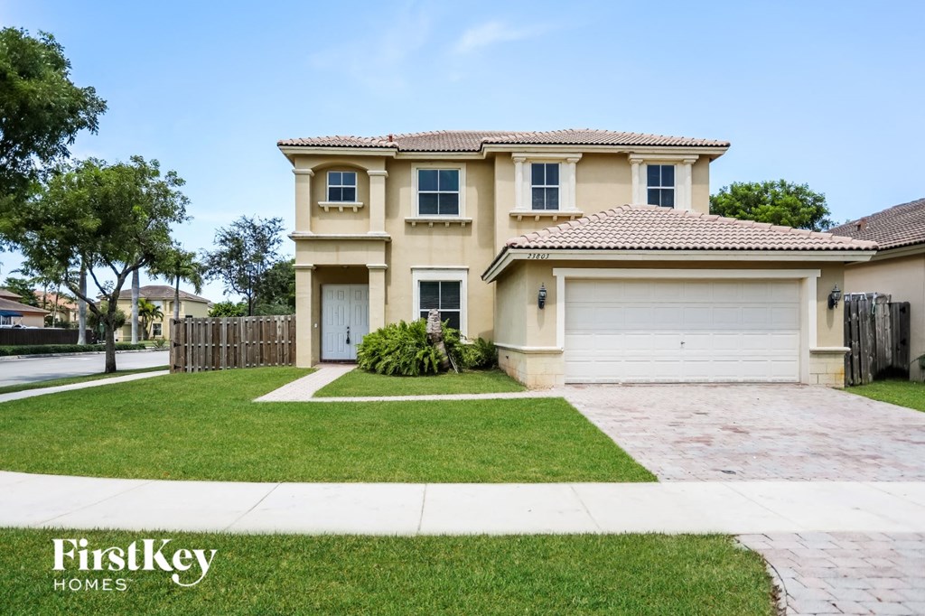 a beige house with a garage and a lawn