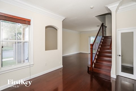 a view of the entryway of a home with a staircase and a large window