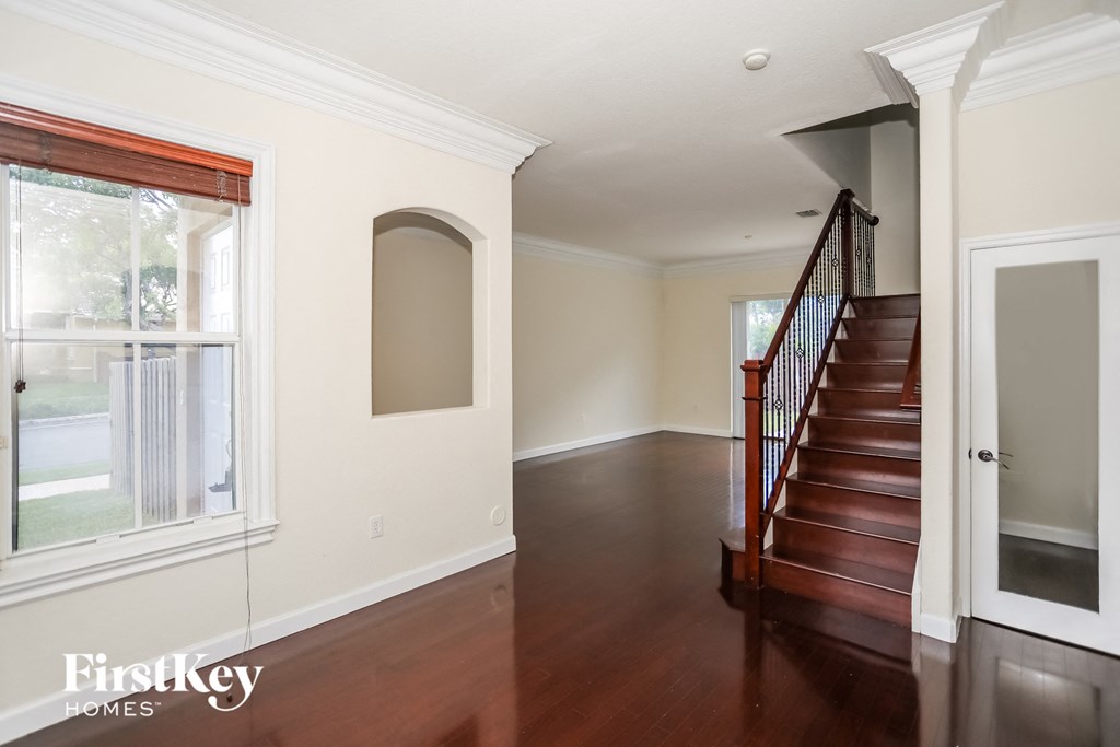 a view of the entryway of a home with a staircase and a large window
