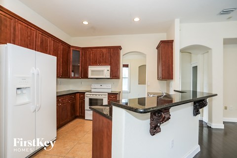 a kitchen with wooden cabinets and white appliances and a counter top
