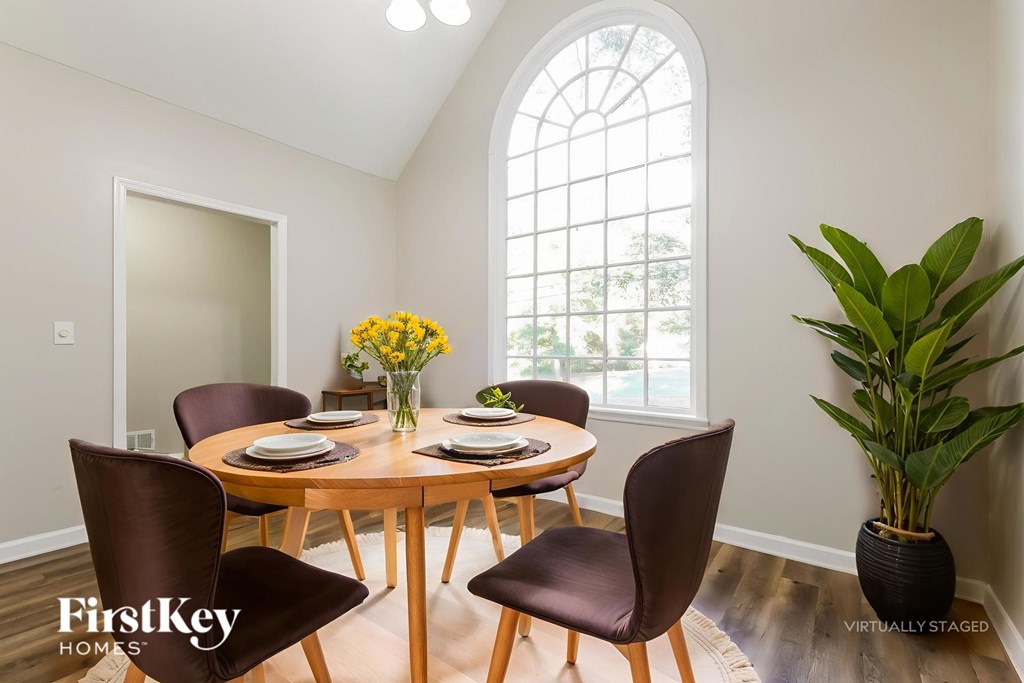 A dining room with a round table and chairs.
