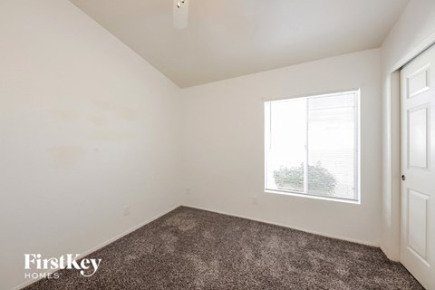 the living room of an apartment with carpet and a window
