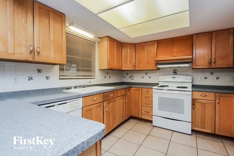 a kitchen with wooden cabinets and white appliances and granite counter tops