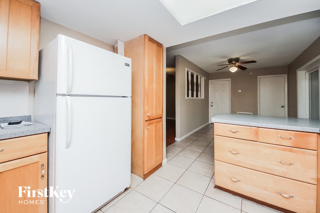 a kitchen with a white refrigerator and wooden cabinets