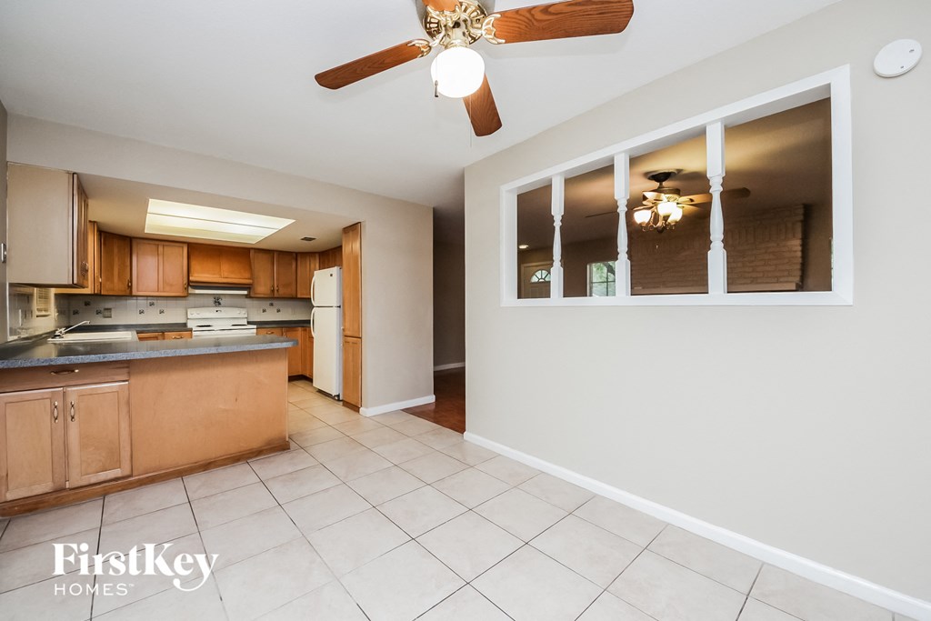 a kitchen with wooden cabinets and a ceiling fan