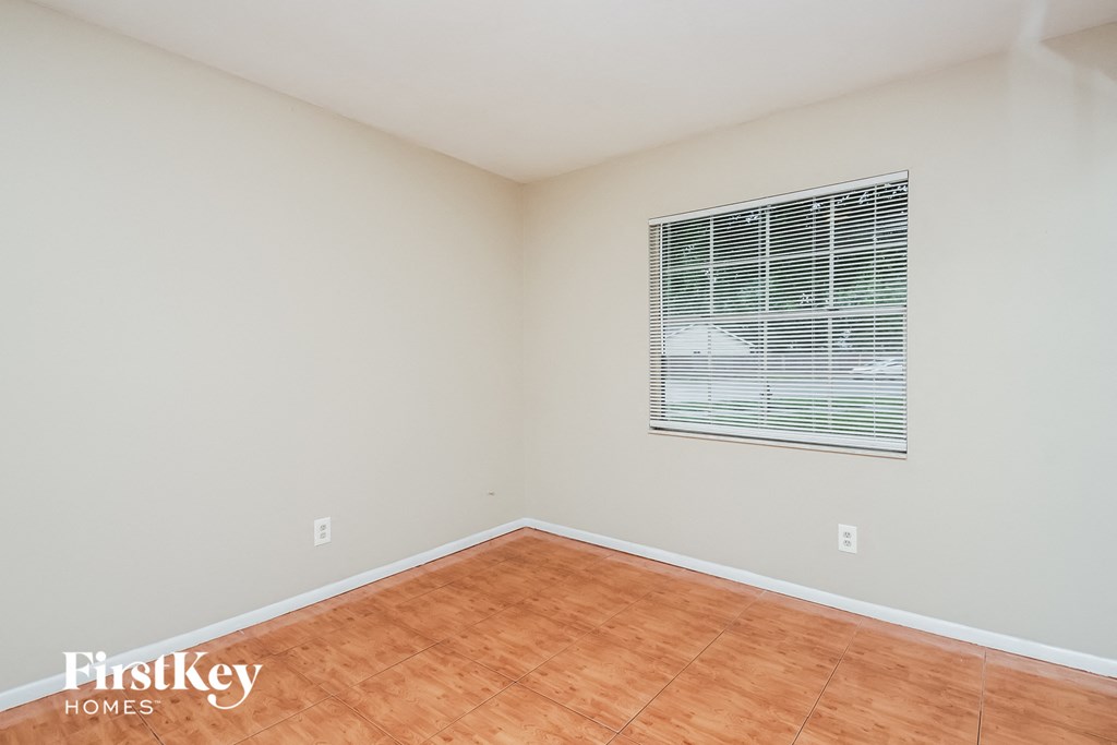 the living room of an empty house with wood floors and a window