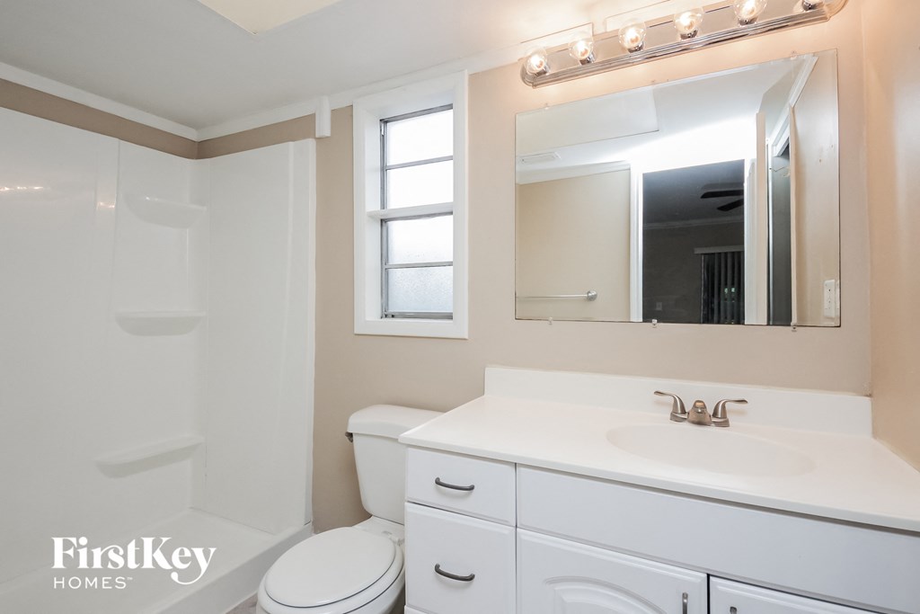 a bathroom with a sink toilet and a mirror