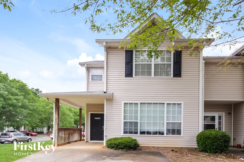 a white house with black shutters and a driveway