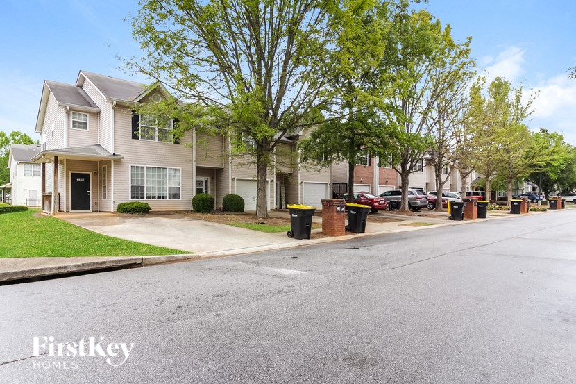 an empty street in front of an apartment building with trees