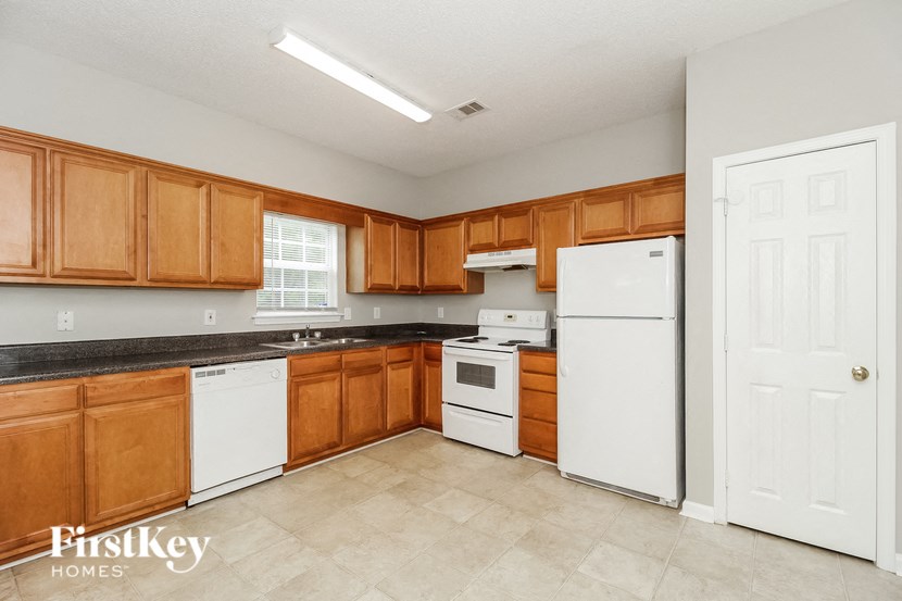 a kitchen with wooden cabinets and white appliances and a white refrigerator