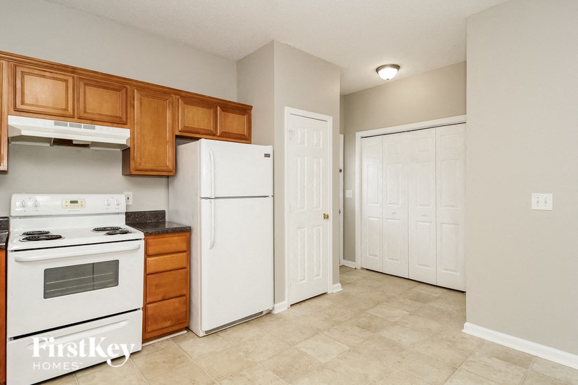 a kitchen with white appliances and wooden cabinets and a white refrigerator