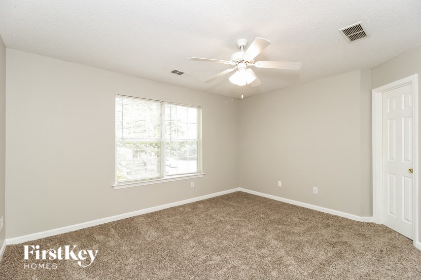 a bedroom with carpet and a ceiling fan