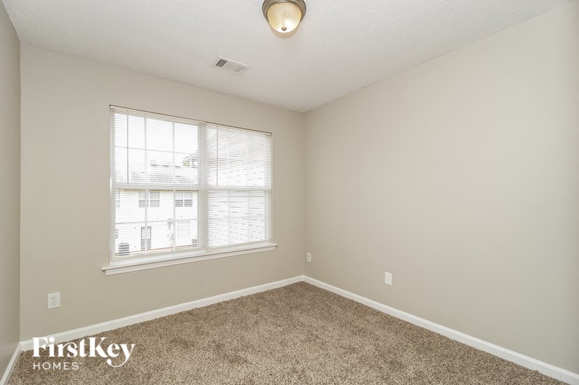 a spacious room with carpet and a large window