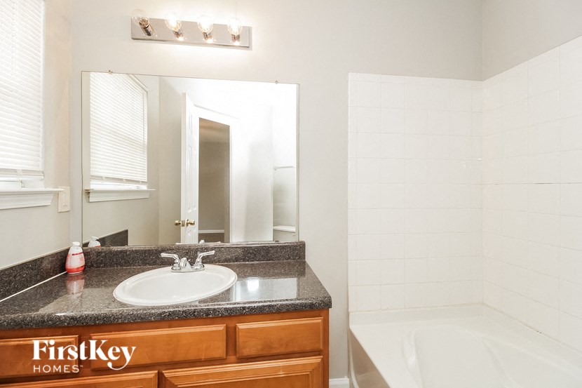 a bathroom with a sink and a tub and a mirror