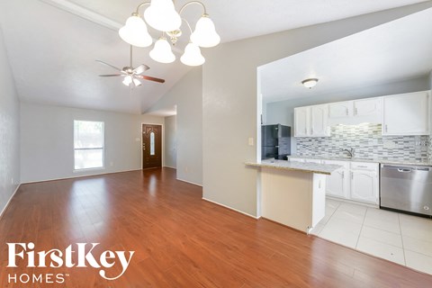A kitchen with a dining table and a refrigerator.