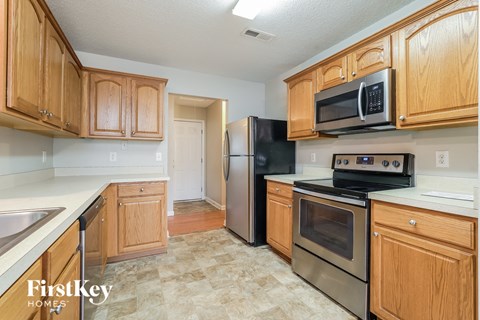 a kitchen with wooden cabinets and stainless steel appliances