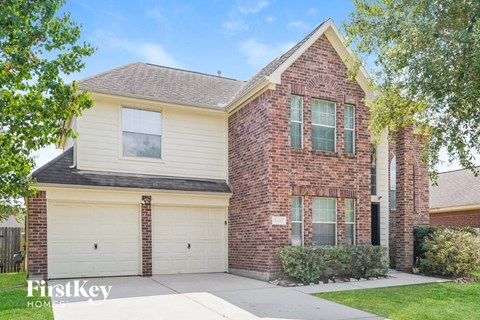 A brick house with a garage door and a window.