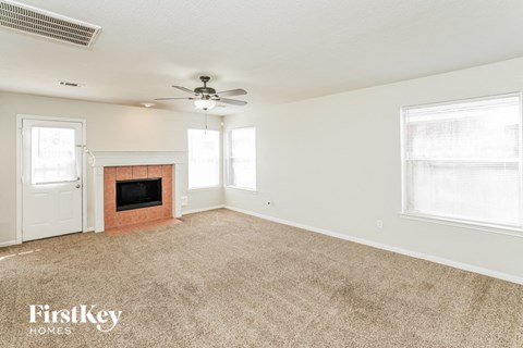 A room with a fireplace and a fan on the ceiling.
