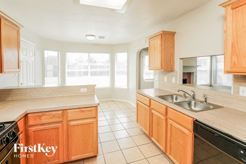 A kitchen with wooden cabinets and a stove top oven.